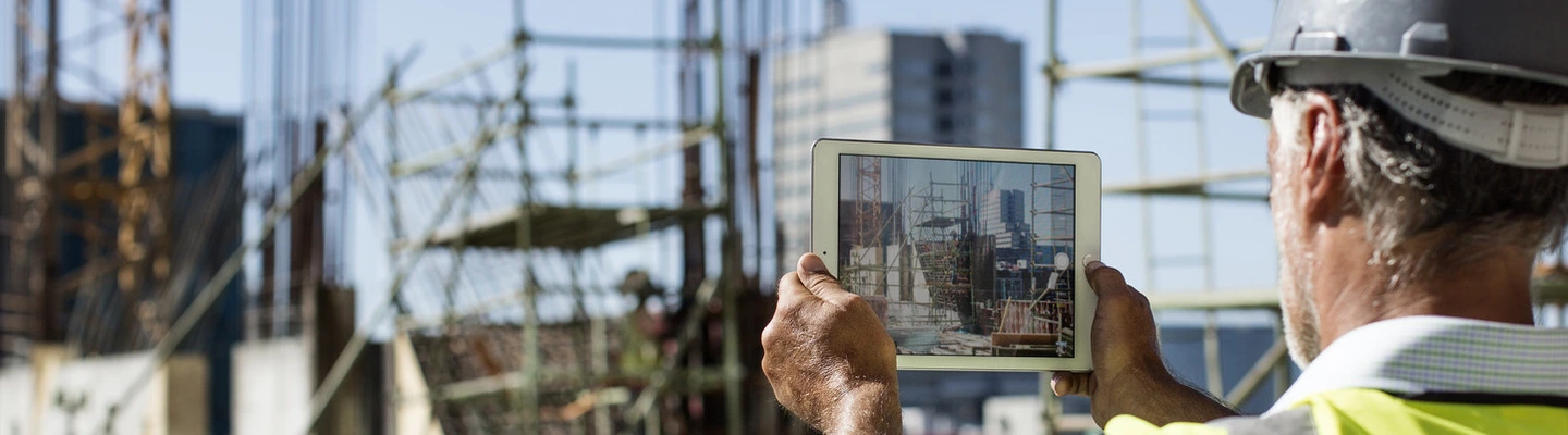 Construction professional holding a tablet to illustrate golden thread training